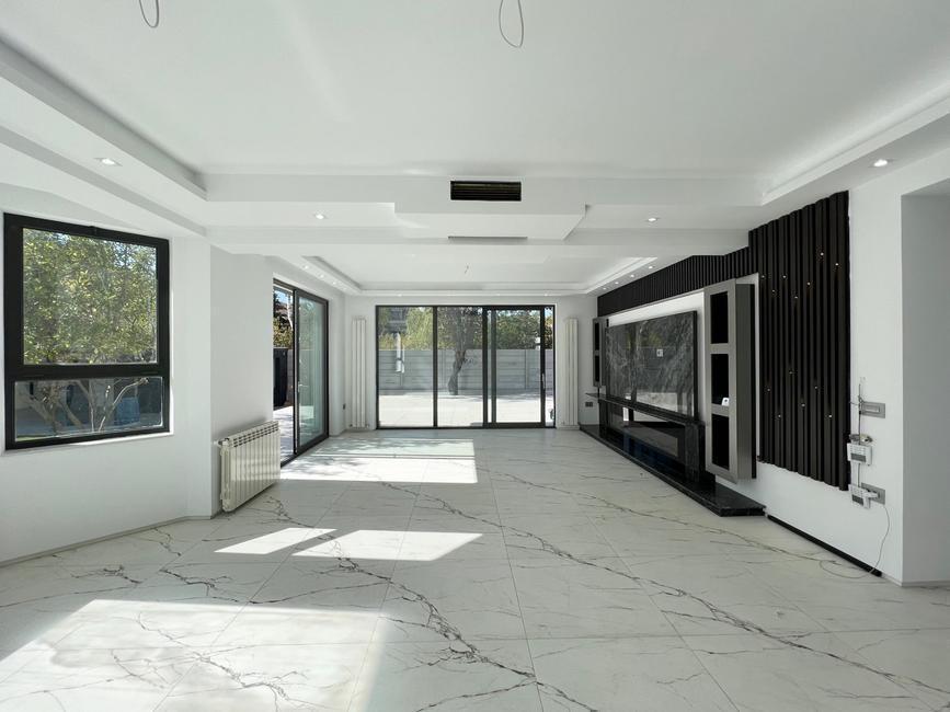 Bright open-plan living space with marble flooring and modern feature wall